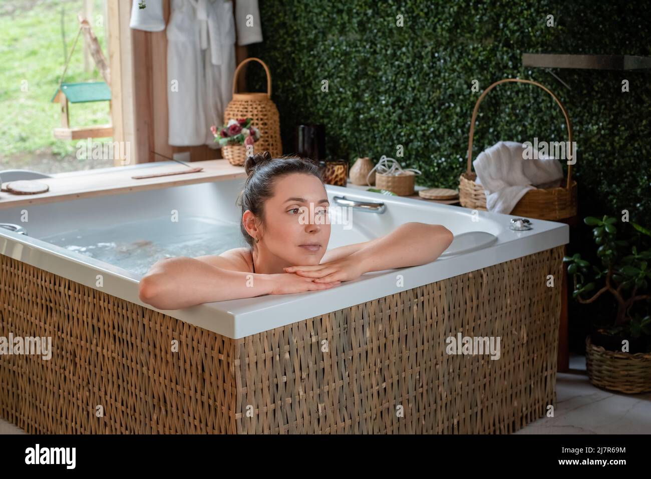 Relaxed Woman resting head in hands in hot tub Stock Photo Alamy