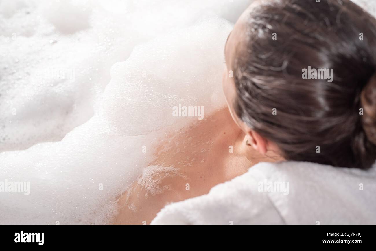 Woman relaxing in hot bath tub with soap foam Stock Photo