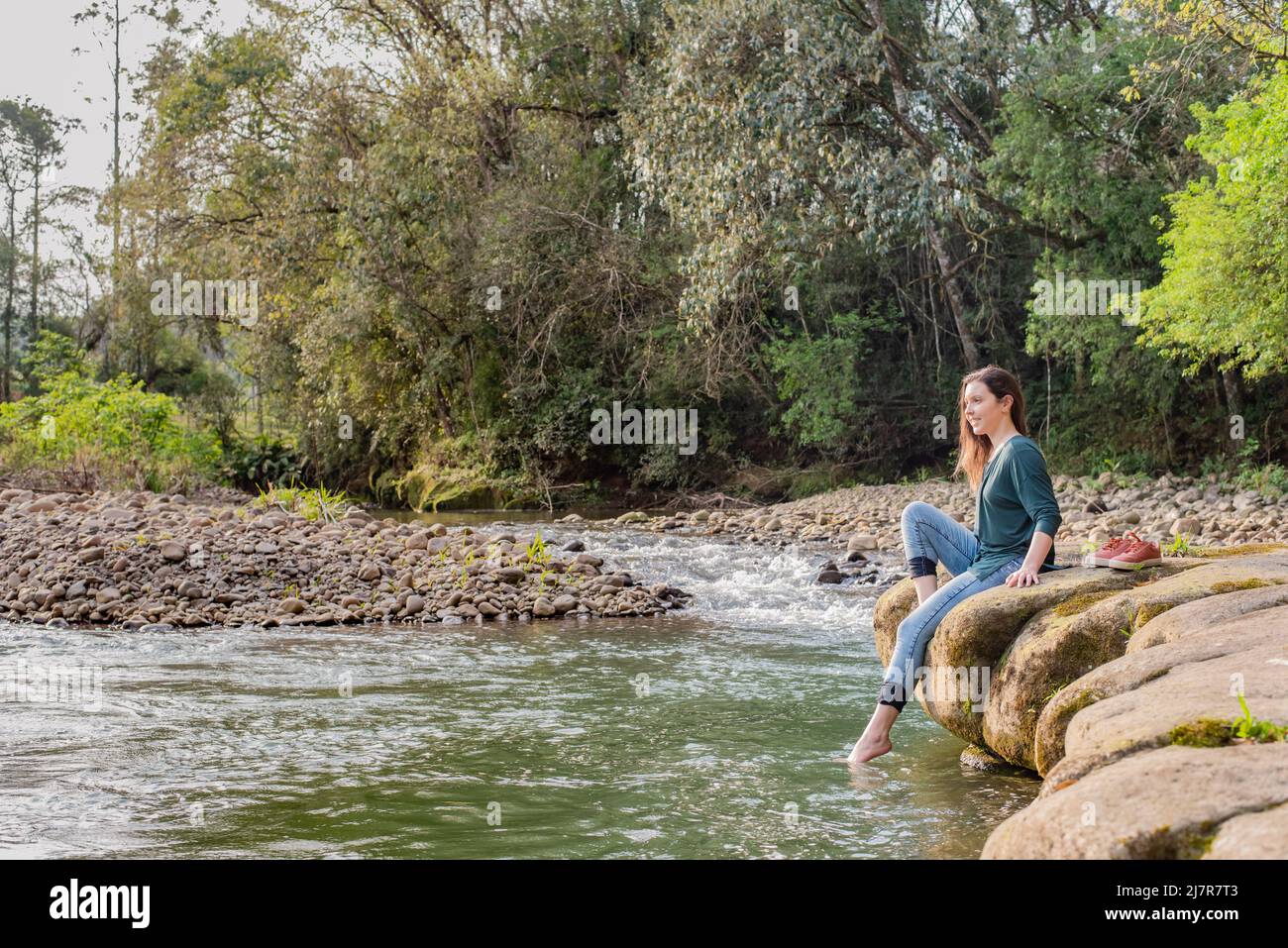 Woman sitting on a rock and relaxing in nature Stock Photo - Alamy