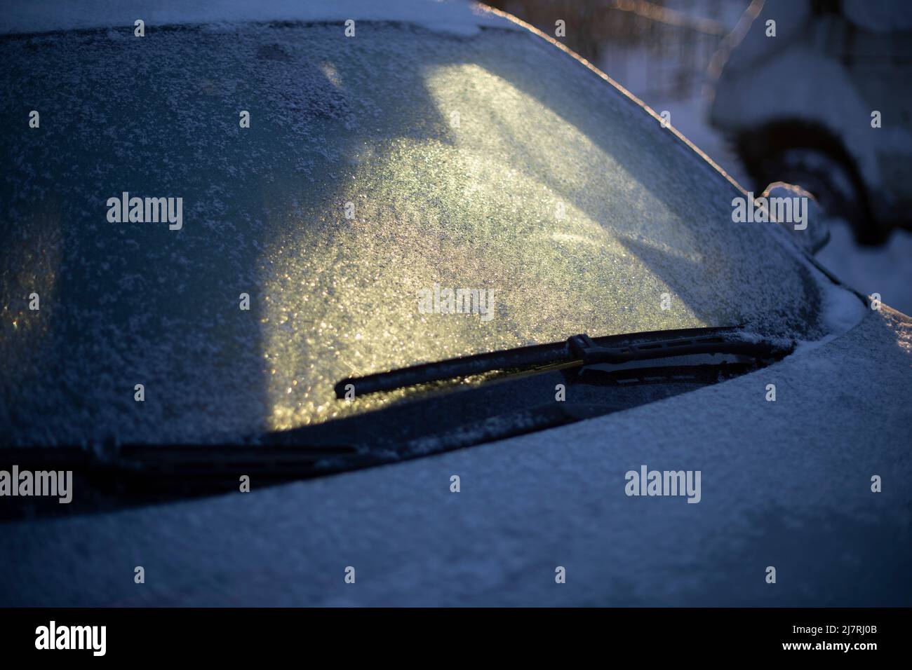 Frozen car window. Ice on windshield of transport. Parking in winter