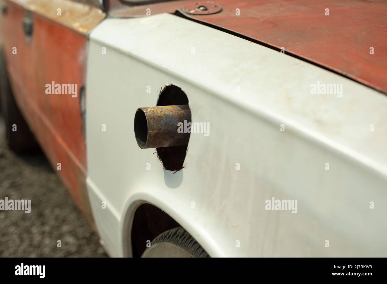 Muffler pipe in race car. Cut hole for exhaust pipe in car. Modernized