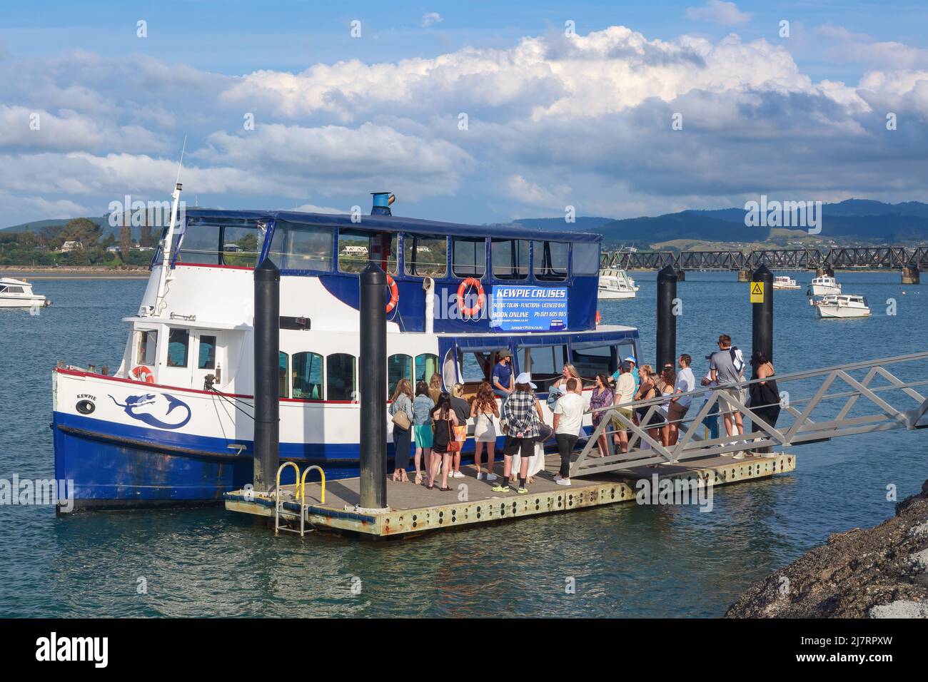 A small tour boat, the 'Kewpie', taking on passengers in Tauranga Harbour, Tauranga, New Zealand Stock Photo