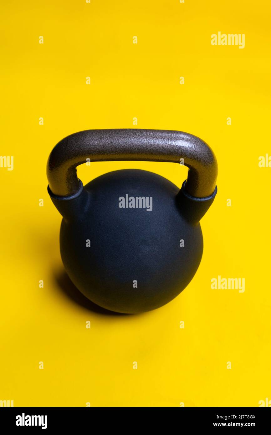 Isolated kettlebell black space yellow ackground fitness cast dumbbell