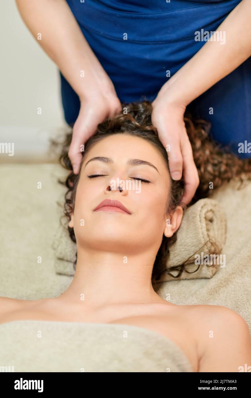 Crop Unrecognizable Masseur Doing Head Massage To Female Client With Curly Hair Lying On Towel