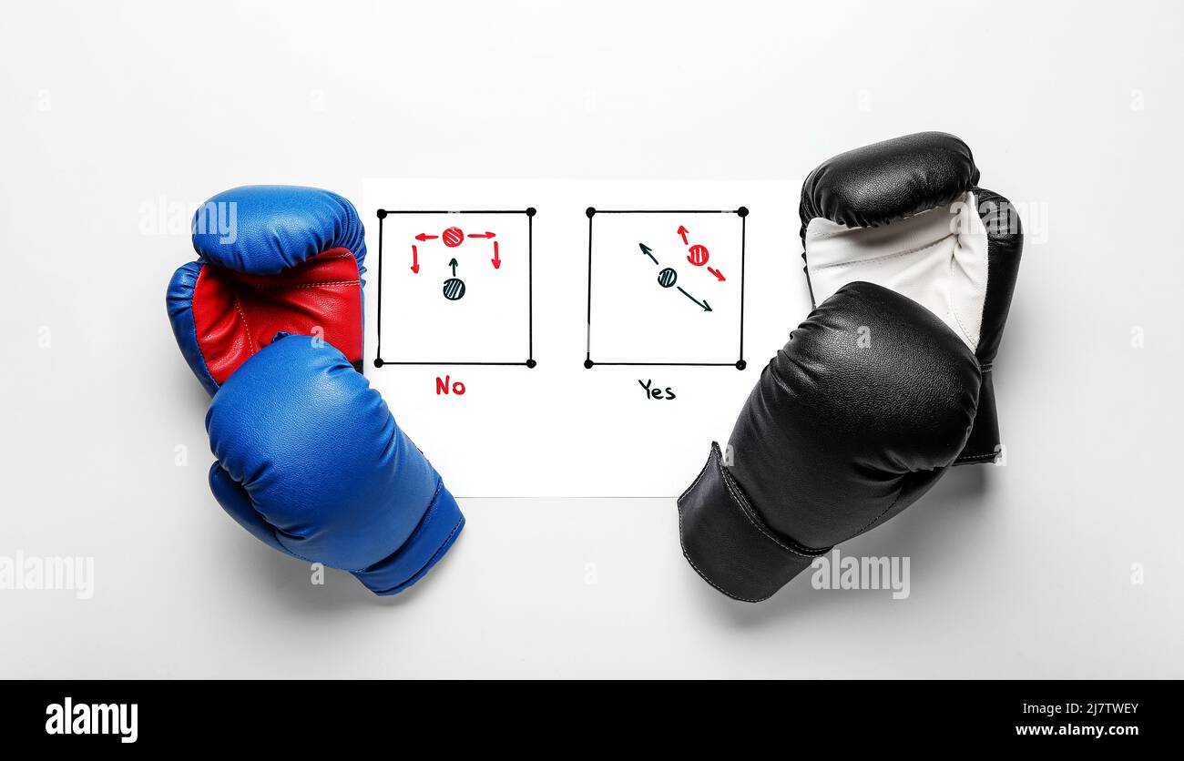 Paper with drawn scheme of boxing game and gloves on white background