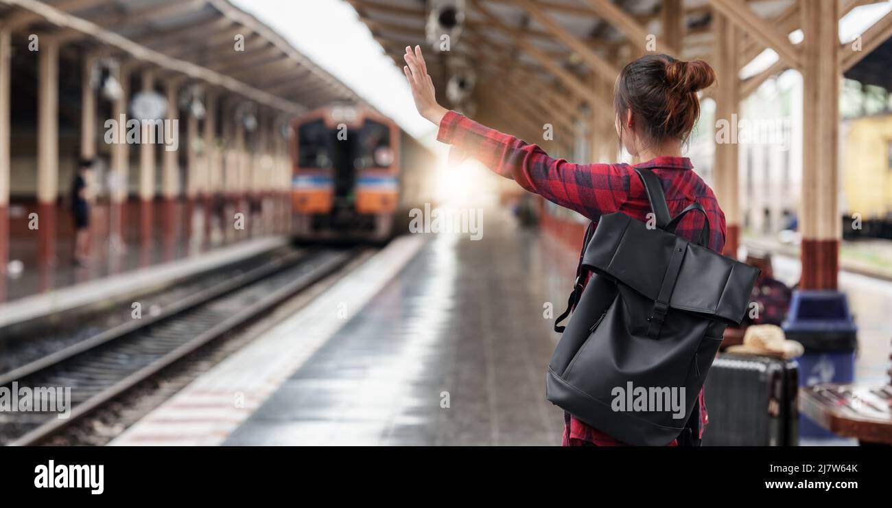 Pretty Young traveler woman planning trip at train station. Summer and travel lifestyle concept. Stock Photo