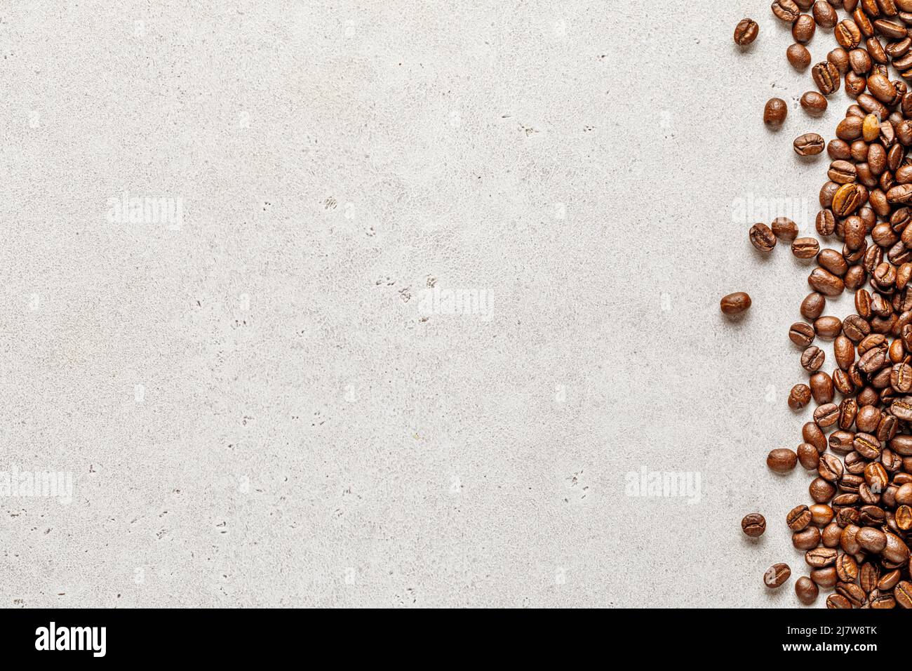Organic coffee beans border over light stone background. Copy space for text Stock Photo