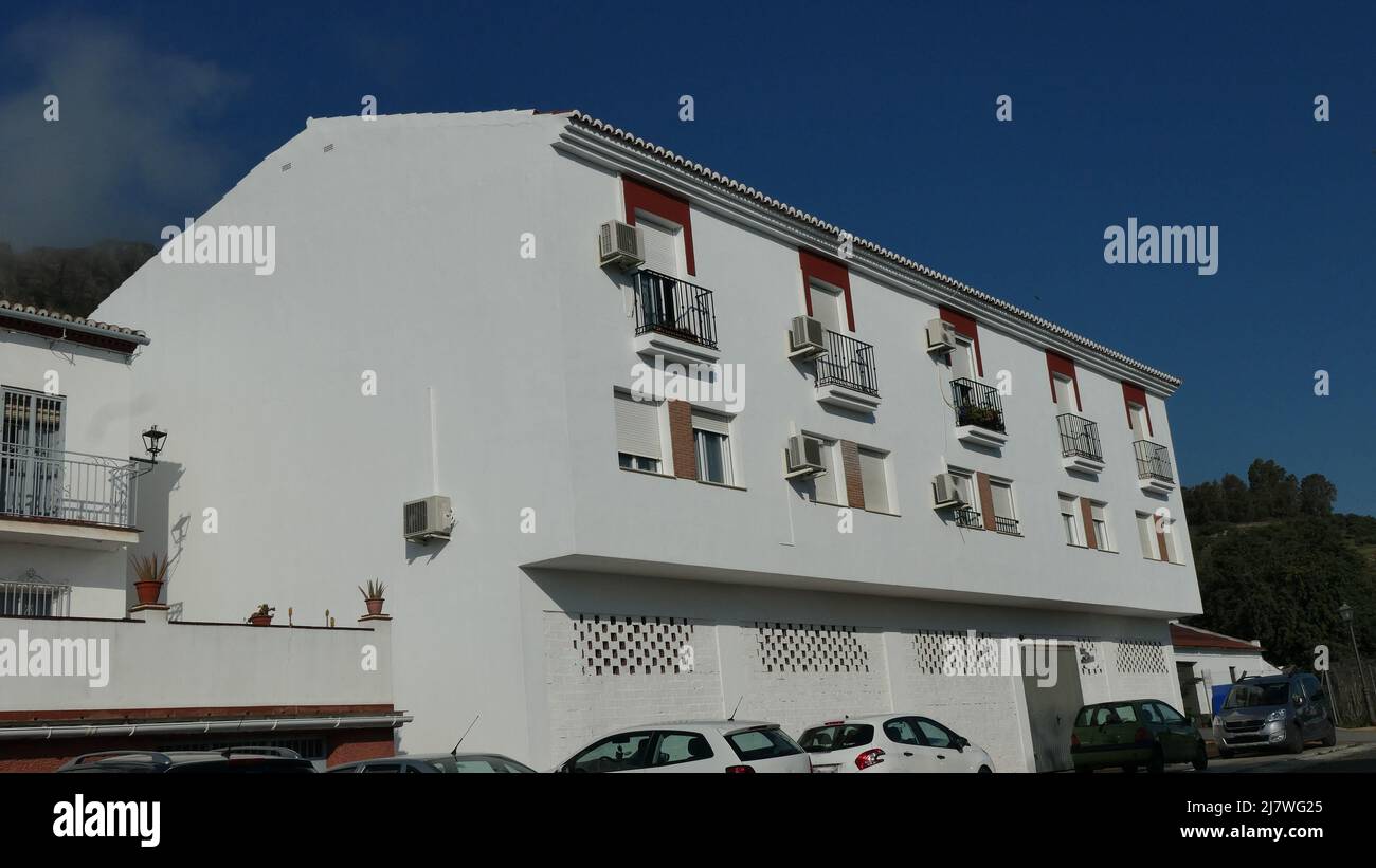 Cars parked below newly painted apartment block in Andalusian village Stock Photo