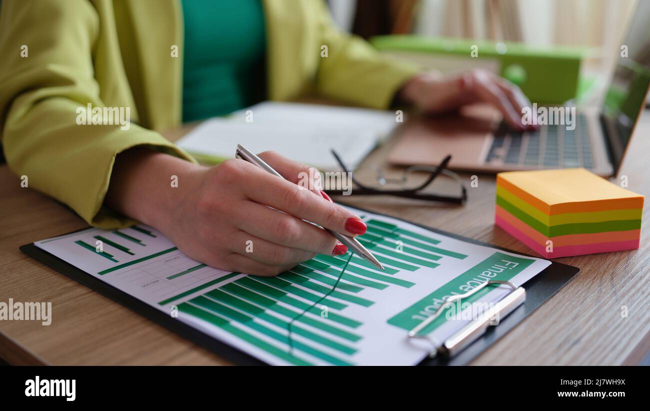 Analyst employee working with financial report on computer and documents Stock Photo