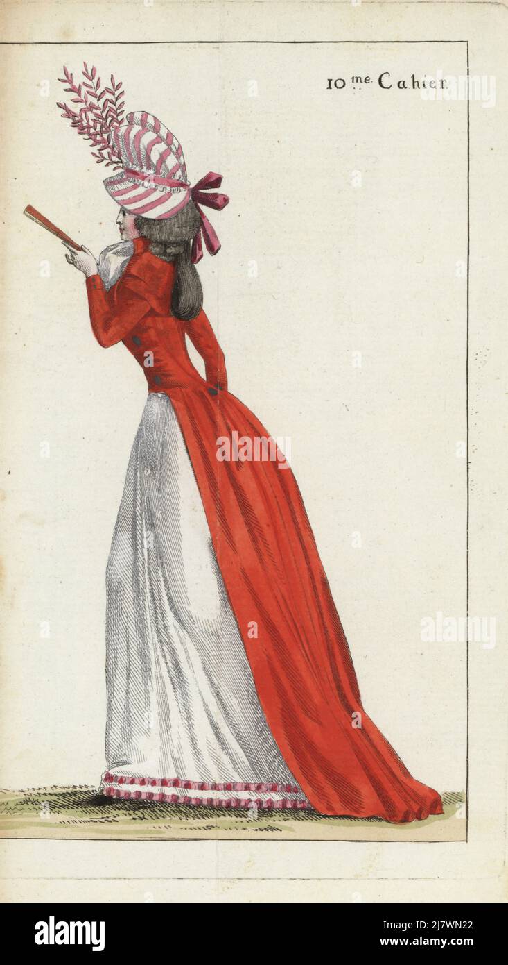 Fashionable woman in casual outfit, en neglige. Chapeau a soufflet in pink striped taffetas, scarlet redingote, gauze fichu, white linen petticoat hemmed with pink ribbon. Handcoloured copperplate engraving from Jean-Antoine le Brun or Lebrun-Tossa’s Journal de la Mode et du Gout, previously Cabinet des Modes, Chez Buisson, Paris, and Joseph le Boffe, London, 10me Cahier, 25 May 1790. Stock Photo
