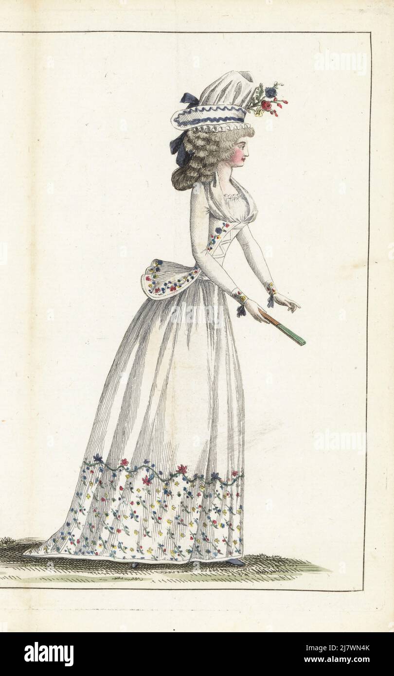 Fashionable woman in gauze bonnet, hair in ringlets, white linen caraco jacket and petticoat embroidered with flowers, gauze fichu, fan  by Arthur. Handcoloured copperplate engraving from Jean-Antoine le Brun or Lebrun-Tossa’s Journal de la Mode et du Gout, previously Cabinet des Modes, Chez Buisson, Paris, and Joseph le Boffe, London, 16me Cahier, 25 July 1790. Stock Photo