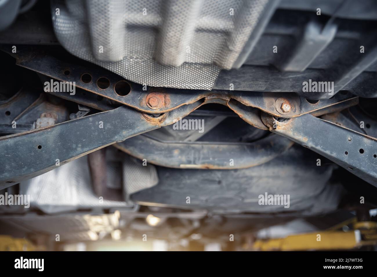 Closeup detail view of bottom car part with rusty broken suspension