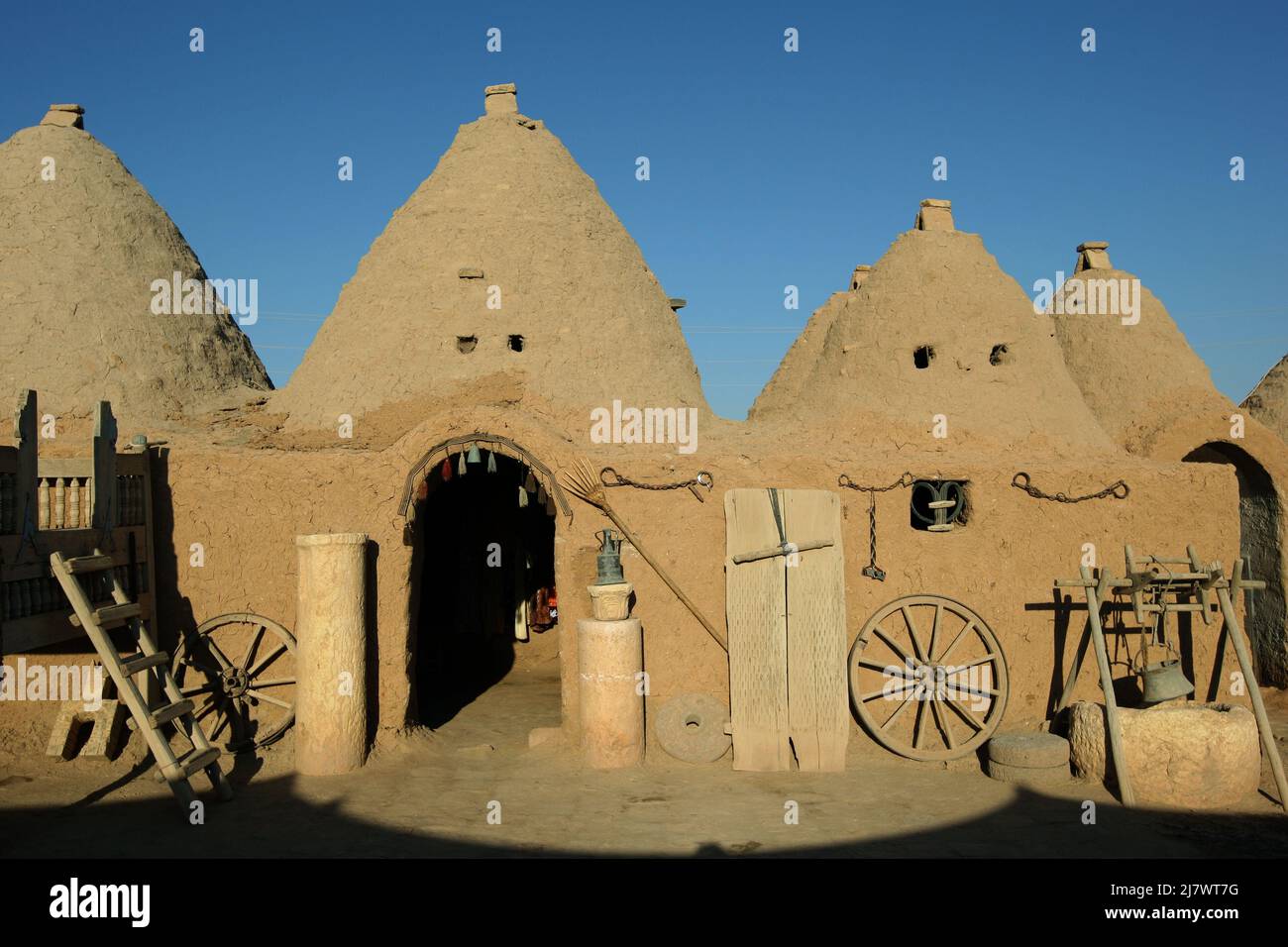 The entrance doorway into an ancient beehive home at Harran in Turkey. The homes are made of mud and clay bricks and are designed to reduce heat. Stock Photo