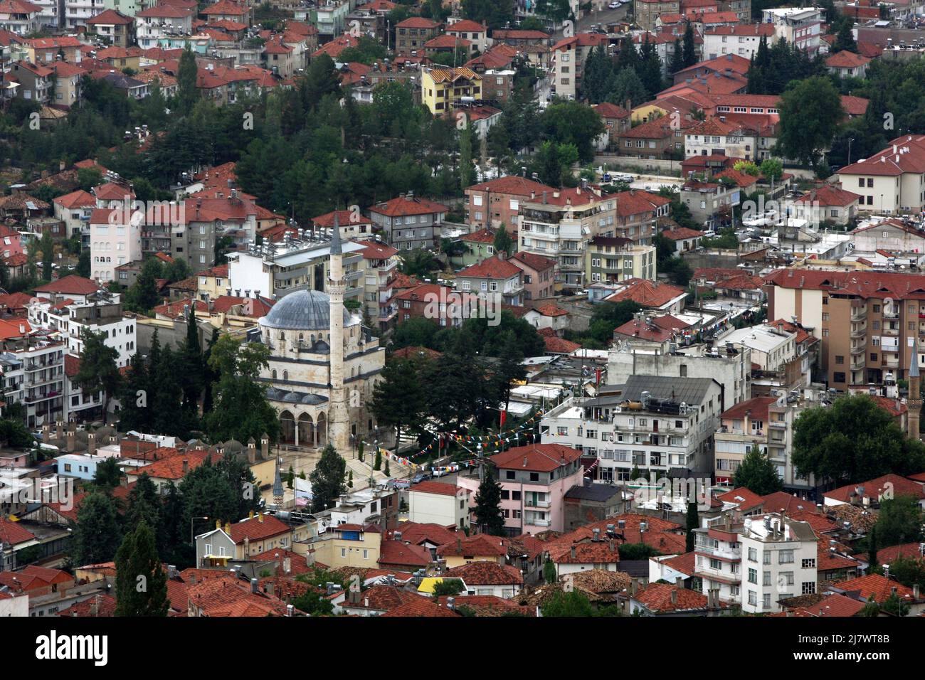 Apartment buildings surround the Ketenci Omer Pasha Mosque in the Taurus Mountains town of Elmali in Turkey. Stock Photo