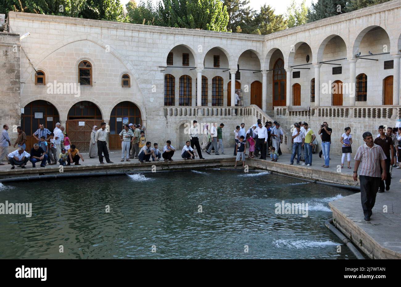 Families relax around Balikli Gol (Pool of Sacred Fish) also known as Abraham's Pool in Golbasi Park at Sanliurfa in Turkey. Stock Photo