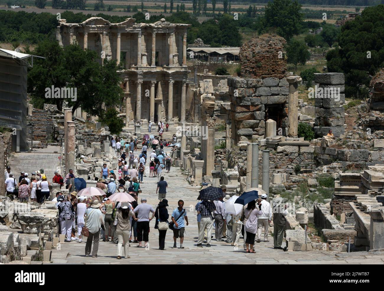 Tourists walk past ancient ruins down Curetes Way at Ephesus towards the Library of Celsus. Ephesus is located near Selcuk in Turkey. Stock Photo