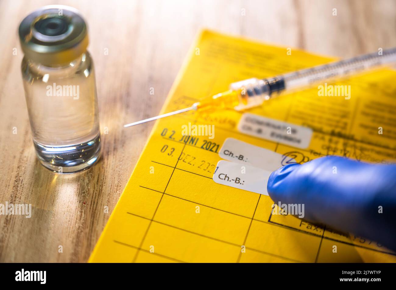 Vaccination card with syringe and injection jar on the subject of vaccinations Stock Photo