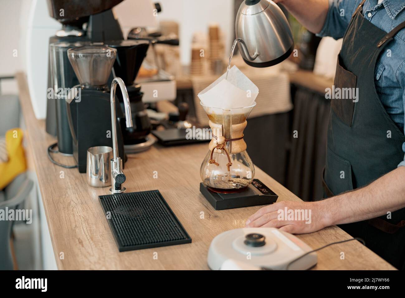 Close up of barista pouring water to make coffee using manual drip