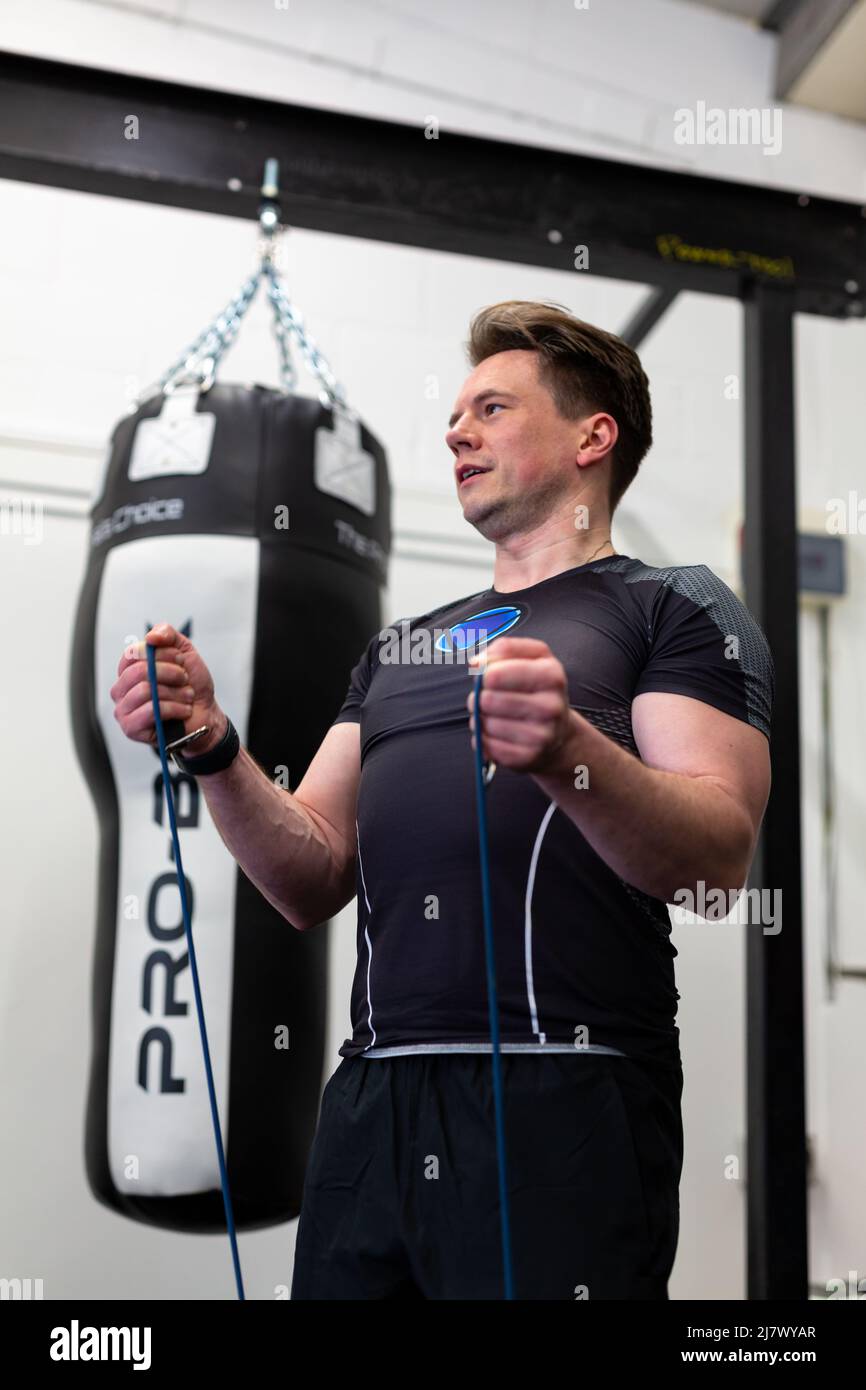 Ipswich Suffolk UK April 03 2022: A fit and healthy man using resistance bands for a upper body workout Stock Photo