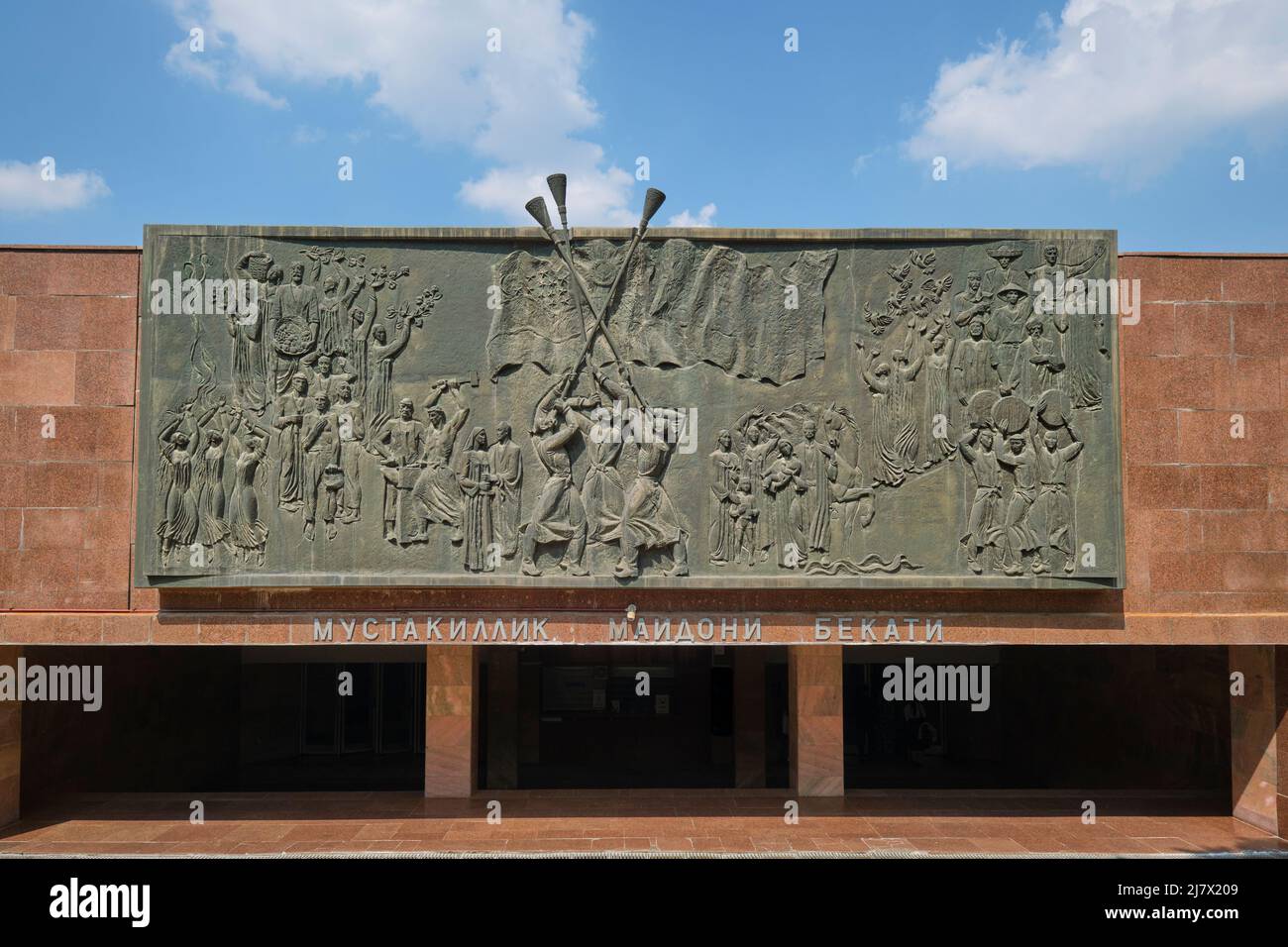 The large, bronze frieze at the entrance to the Mustaqilliq Maidoni metro station. It depicts Uzbek work, celebrations. In Tashkent, Uzbekistan. Stock Photo