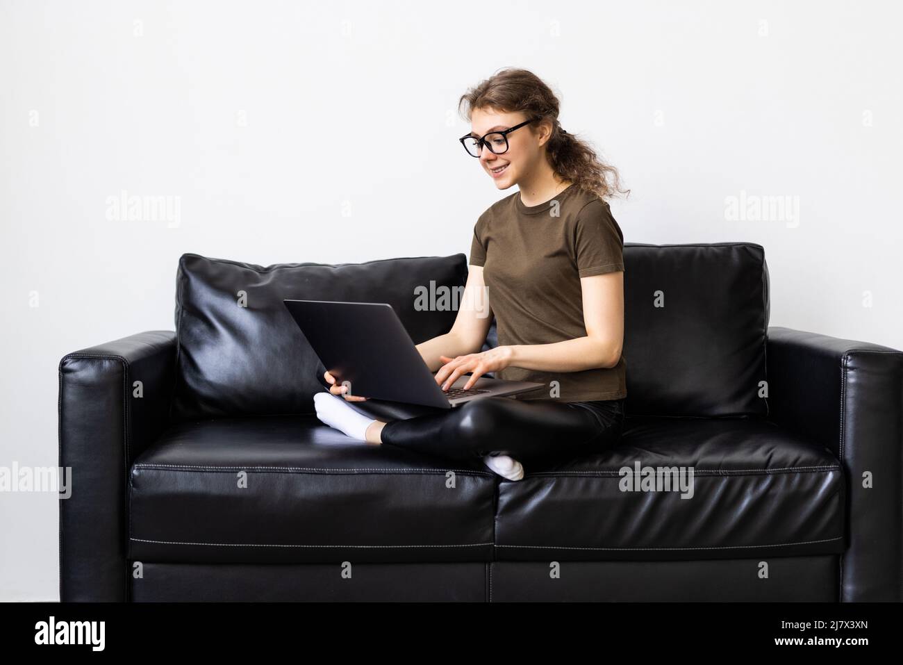 Pensive young asian woman using laptop computer while sitting on a ...