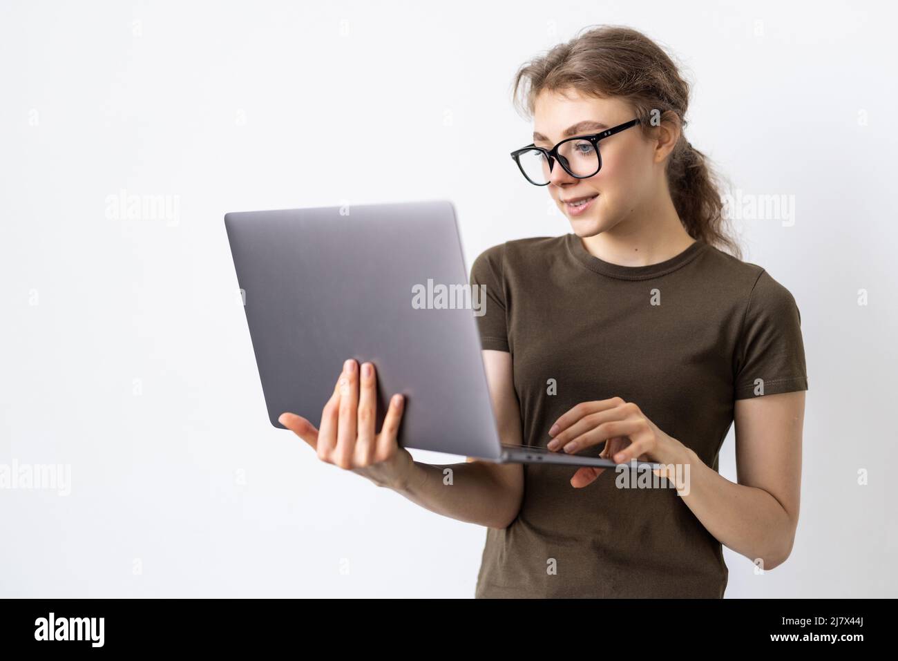 Young woman holding laptop on white background Stock Photo - Alamy