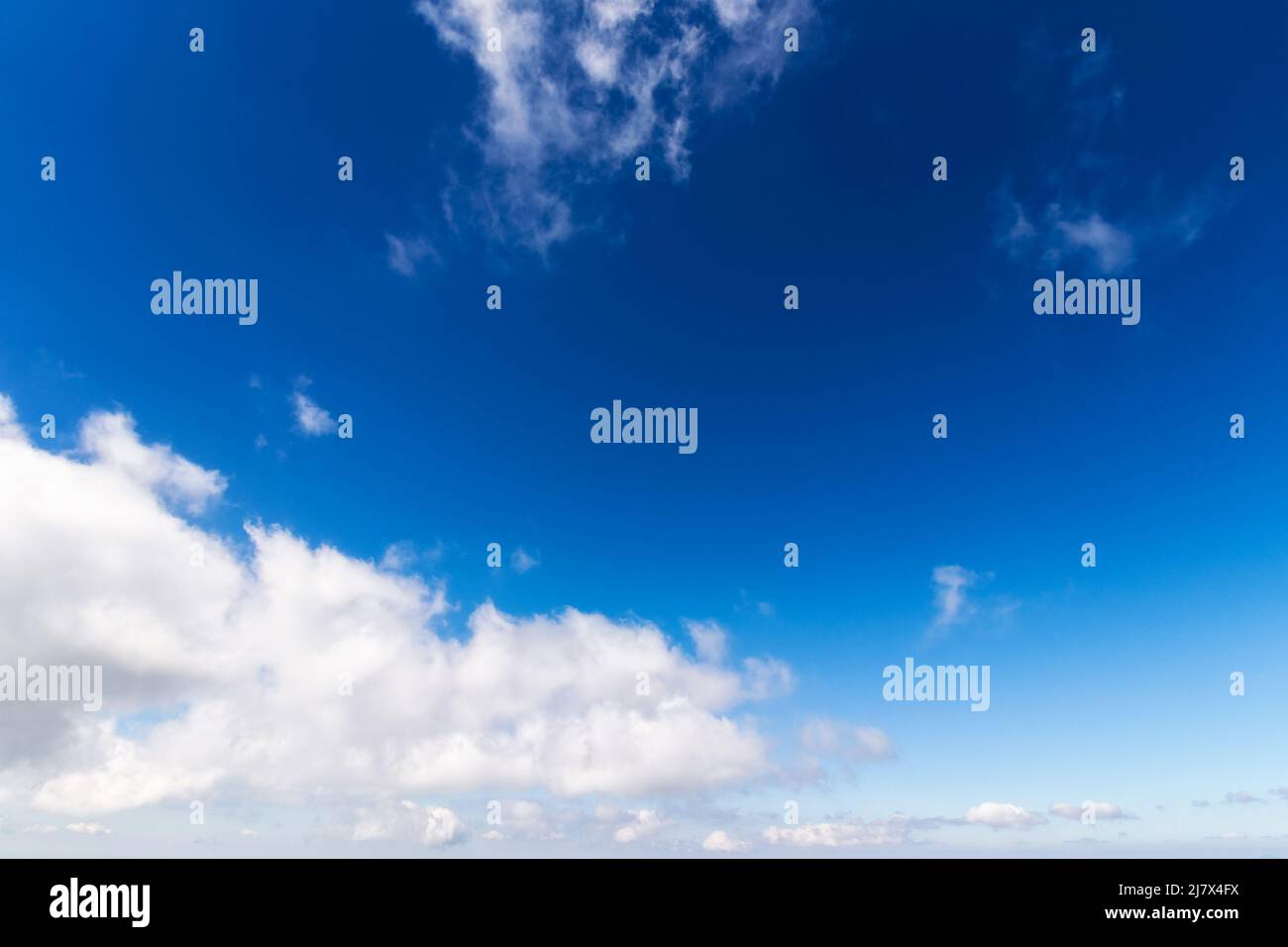 blue sky background. white fluffy clouds above horizon. sunny summer weather at high noon Stock Photo