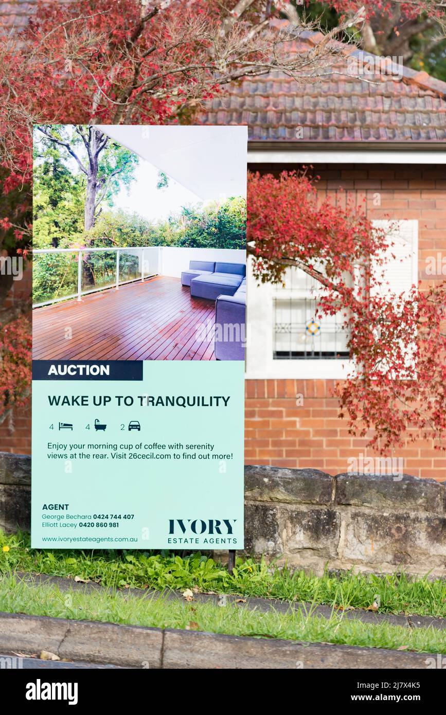 A sign at the front of a house advertising an Australian (brick and tile roof) home for sale by auction in Sydney, New South Wales Stock Photo