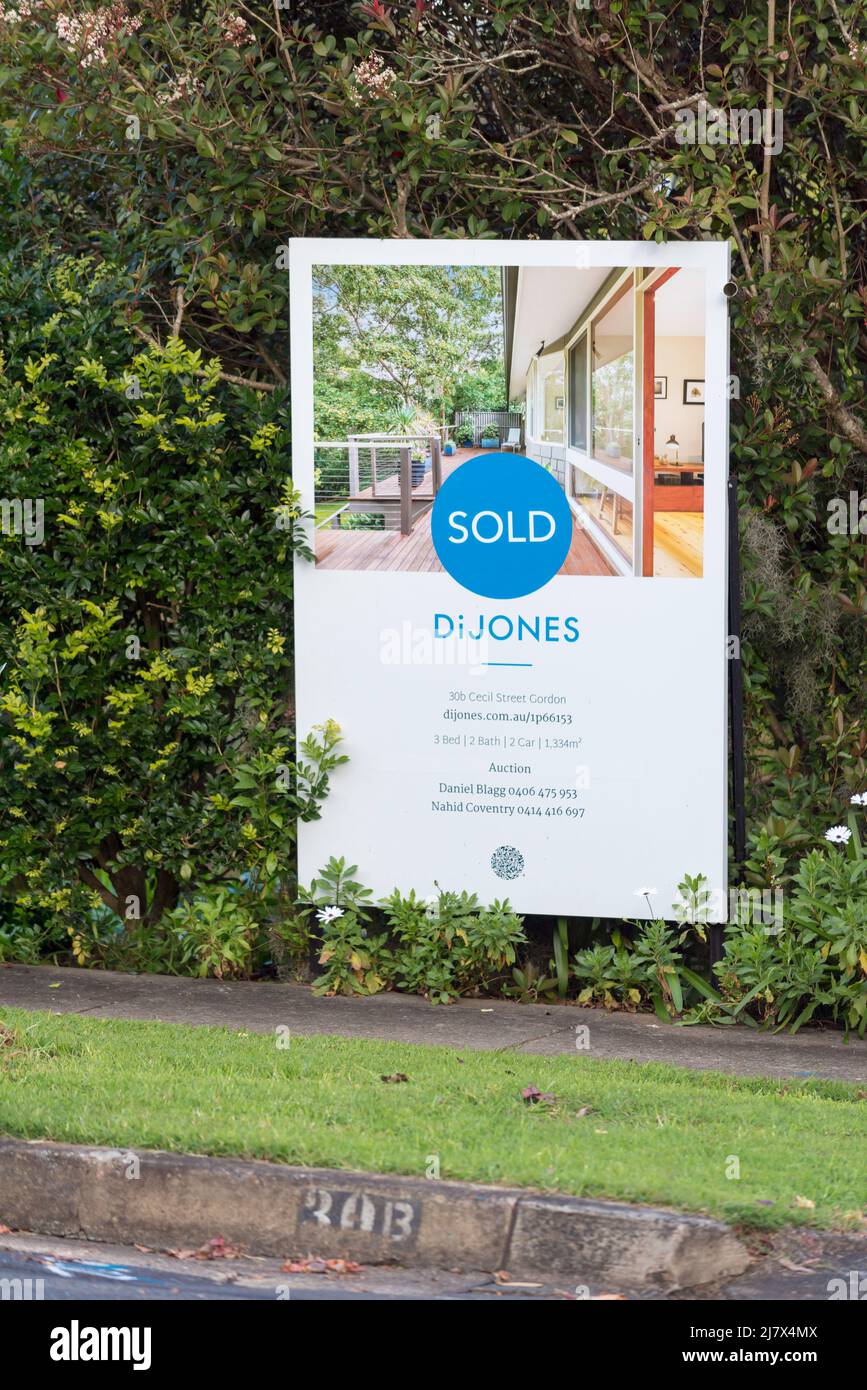 A sign at the front of a house advertising an Australian home for sale by auction and a SOLD sticker, in Sydney, New South Wales Stock Photo