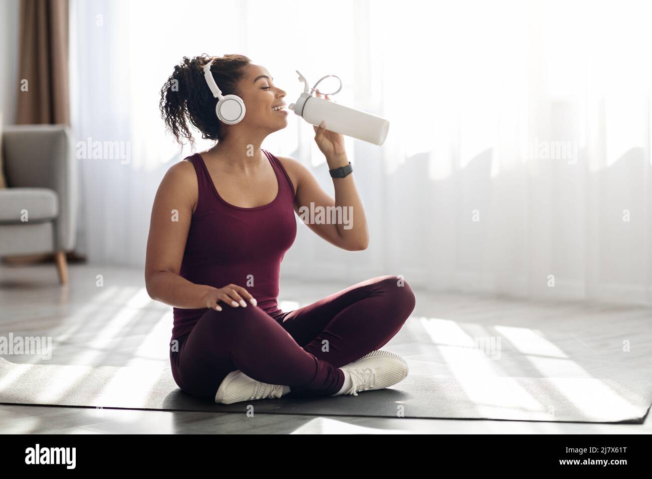 Athletic black woman drinking water while exercising Stock Photo