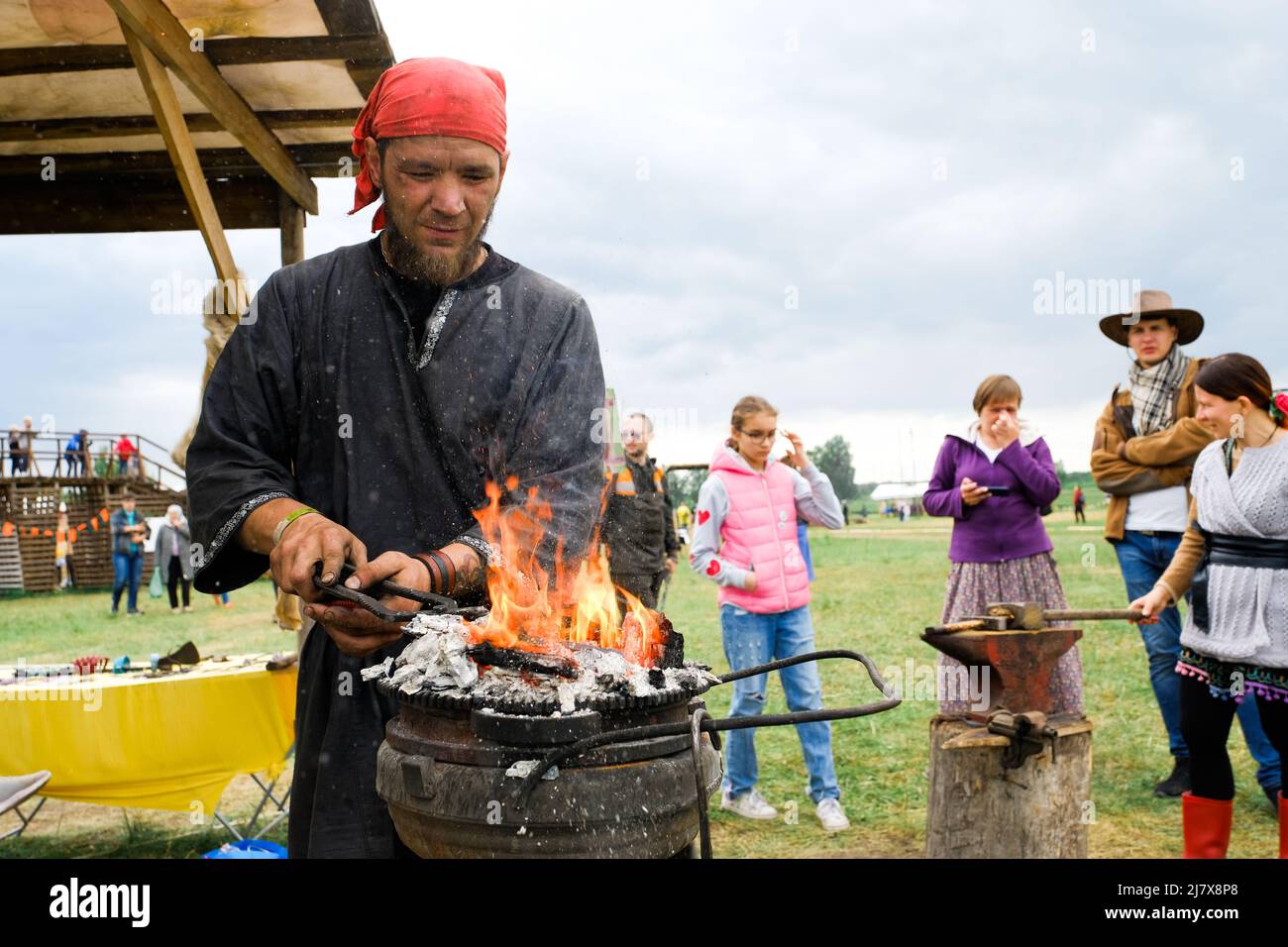 Russia, Tyumen, 15.06.2019. Blacksmith holds a master class on forging at the festival of different Nations. Heats the iron on the fire Stock Photo
