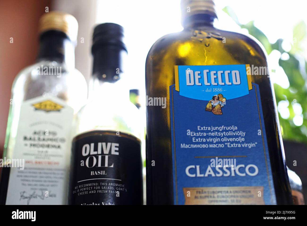 Different kinds of olive oil in a kitchen in a home. Here basil olive oil and De Cecco olive oil. Stock Photo