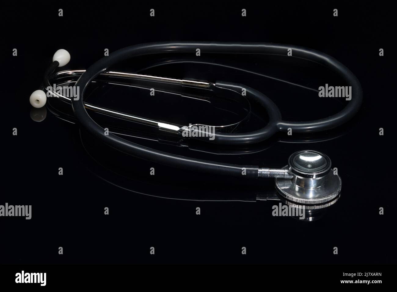 close-up of a stethoscope on a black shiny surface Stock Photo