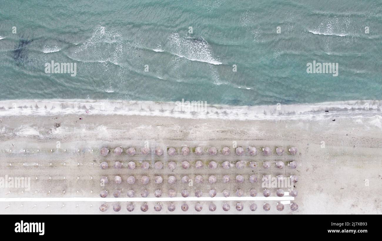 Beautiful aerial shot of popular Romanian beach with sun umbrellas and the agitated Black Sea in spring, Mamaia Stock Photo