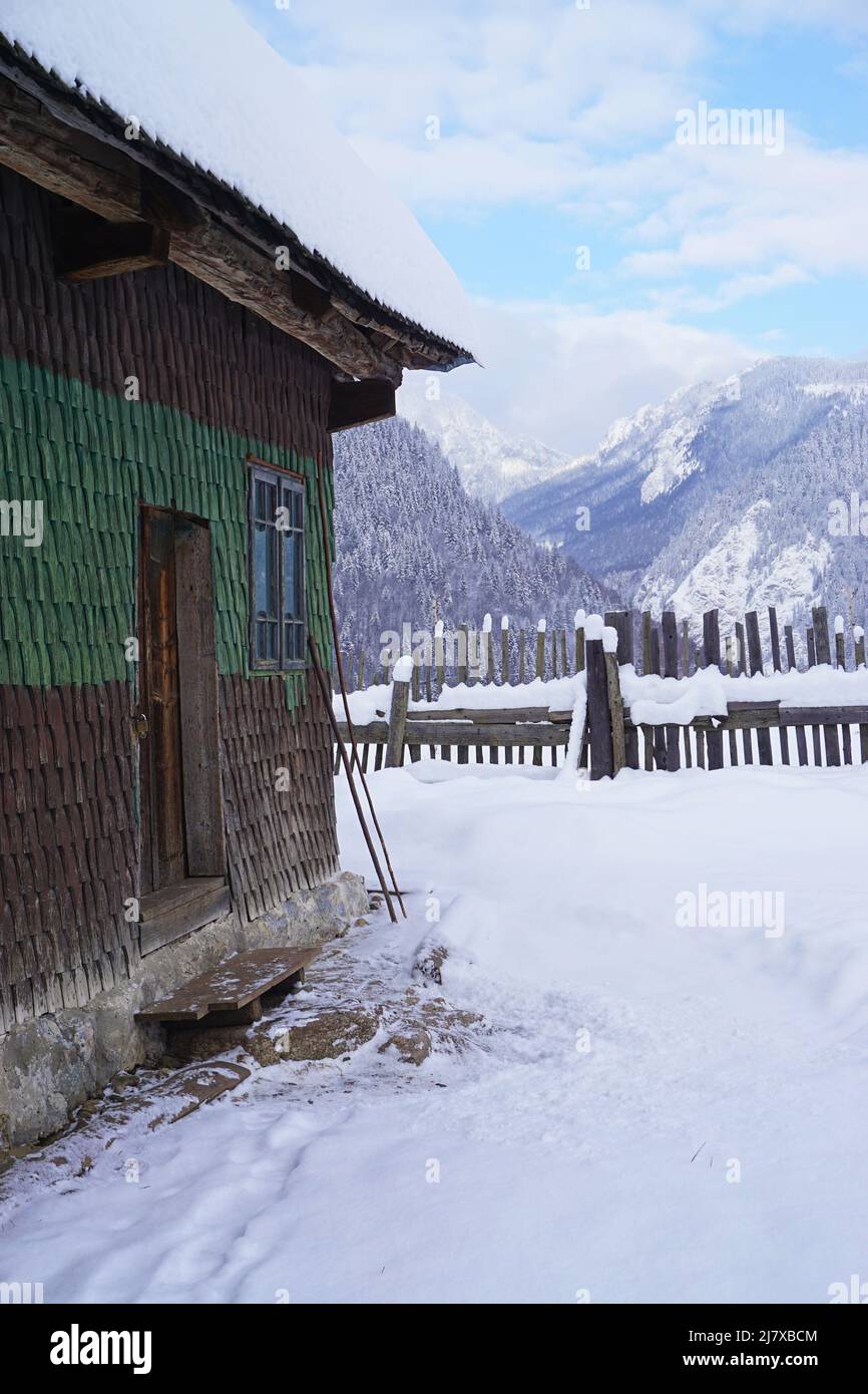 Traditional wooden house during winter in mountain village in the Carpathian Mountains, Romania Stock Photo