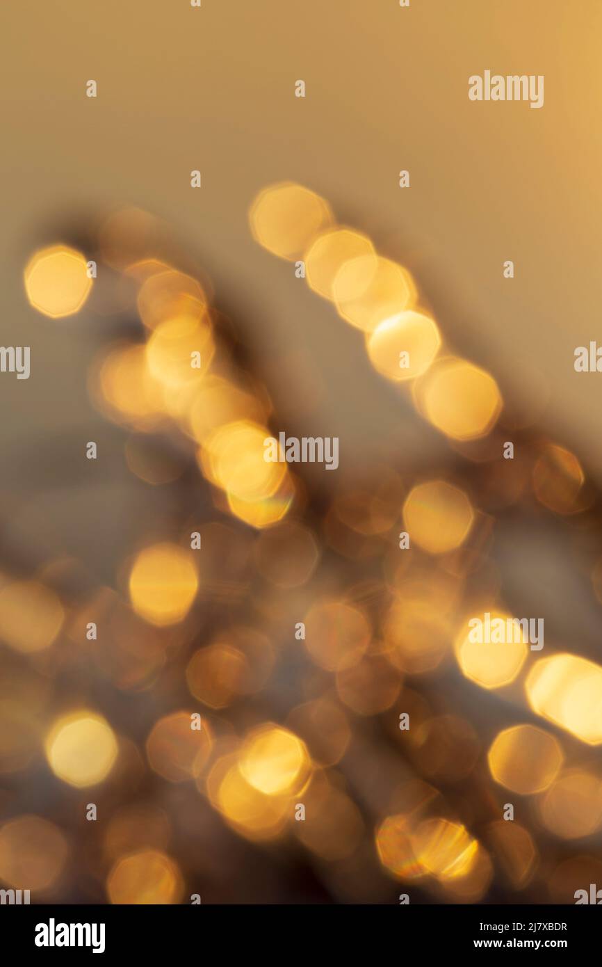 Defocused image of lights, golden hue. Layered golden bokeh spots. High resolution abstract background with copy space. Stock Photo