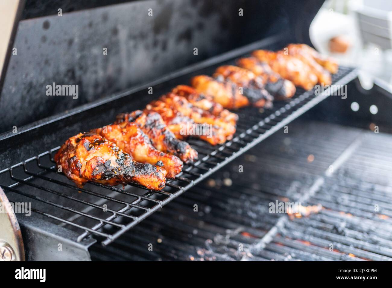 Grilling BBQ chicken drumsticks on outdoor gas grill Stock Photo Alamy