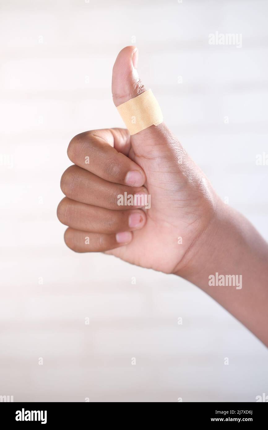 thumb finger with adhesive bandage wrapped around . Stock Photo