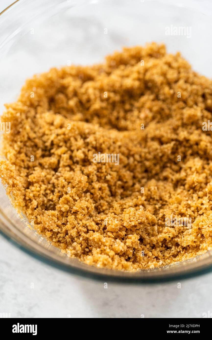 Mixing ingredients in a glass mixing bowl to bake s'mores cupcakes