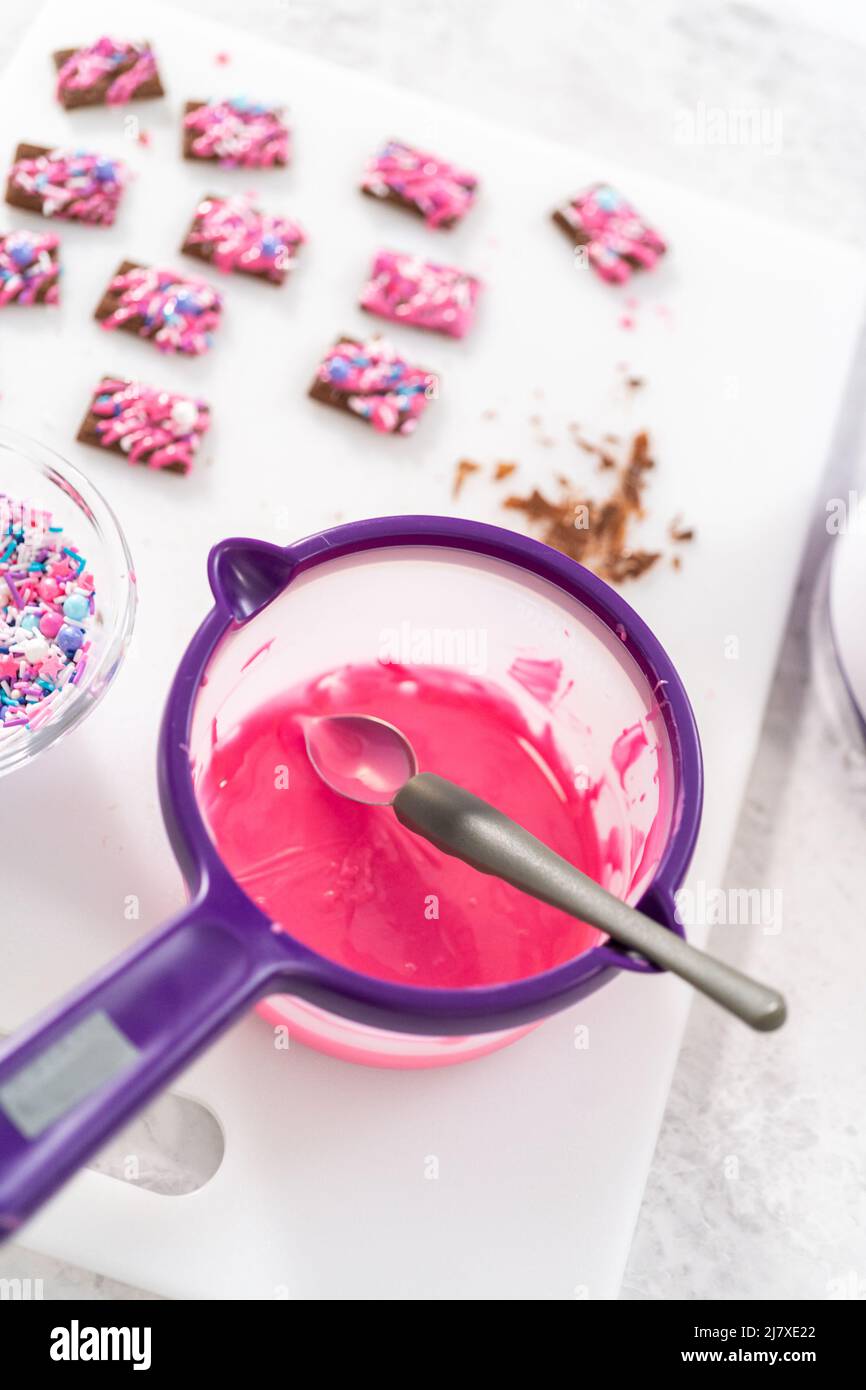 Drizzling melted pink chocolate on top of the mini chocolates and