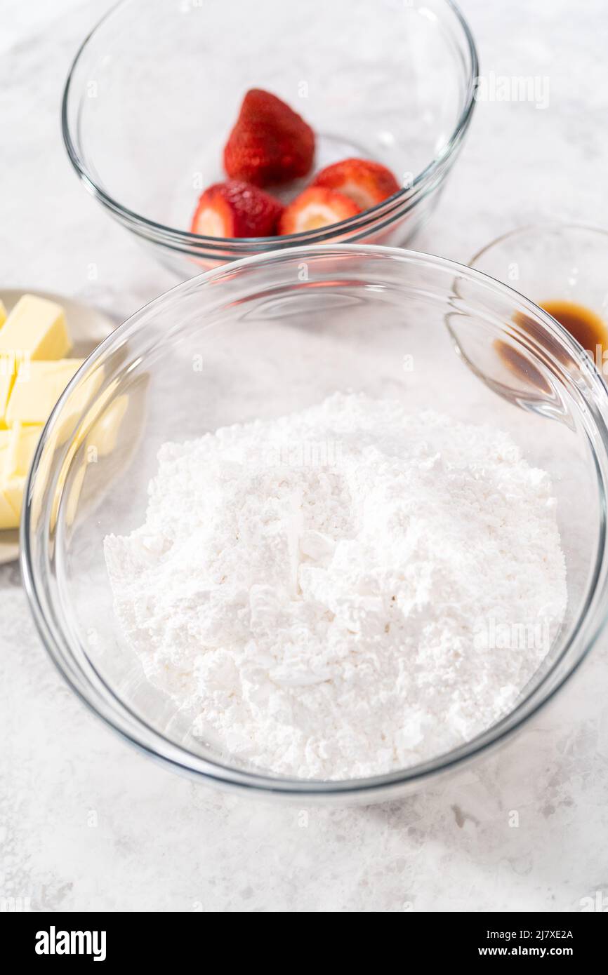 Ingredients in a glass mixing bowls to prepare the strawberry