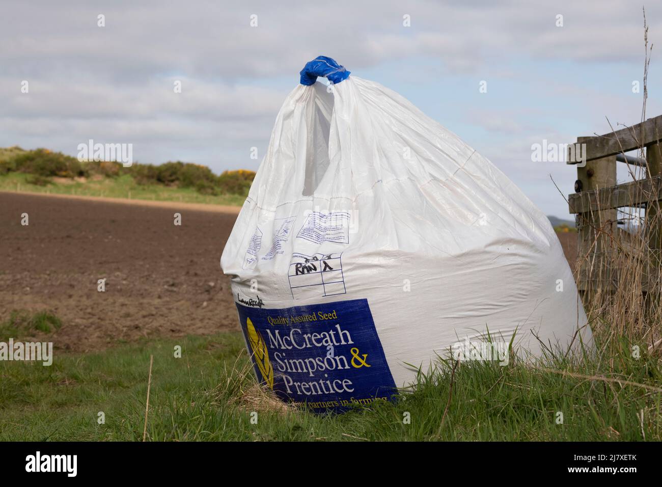 A Bag of Barley Seed at the Entrance to a Ploughed Field Ready for Sowing Stock Photo