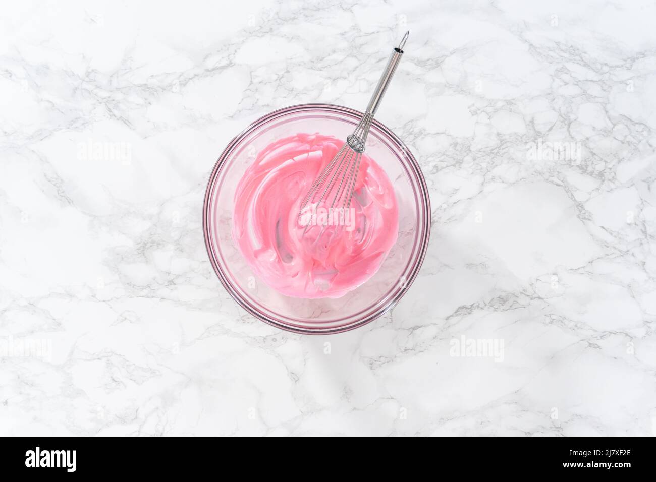 Mixing pink food coloring into the meringue to bake Easter meringue