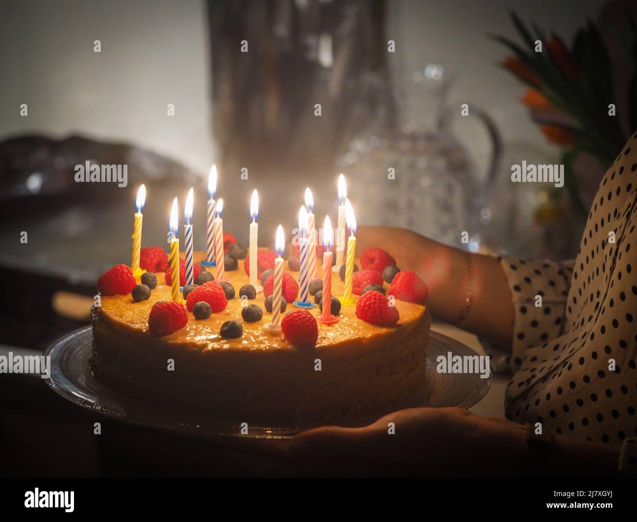 Woman holding a birthday cake with burning candles in hands Stock Photo ...