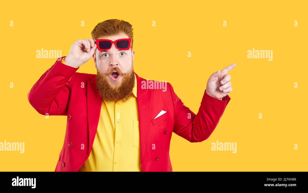 Funny surprised chubby man looks at you with shocked expression, isolated on yellow background. Stock Photo