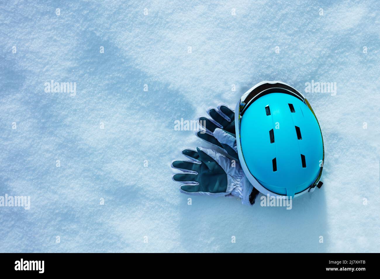 Sport gloves in the snow with blue ski helmet and mask Stock Photo