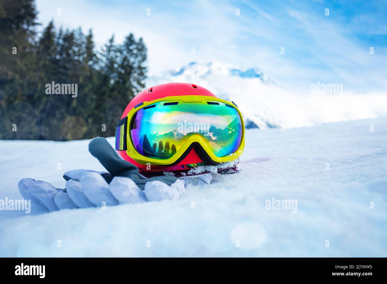 Helmet with ski mask and gloves in snow mountain range on back Stock