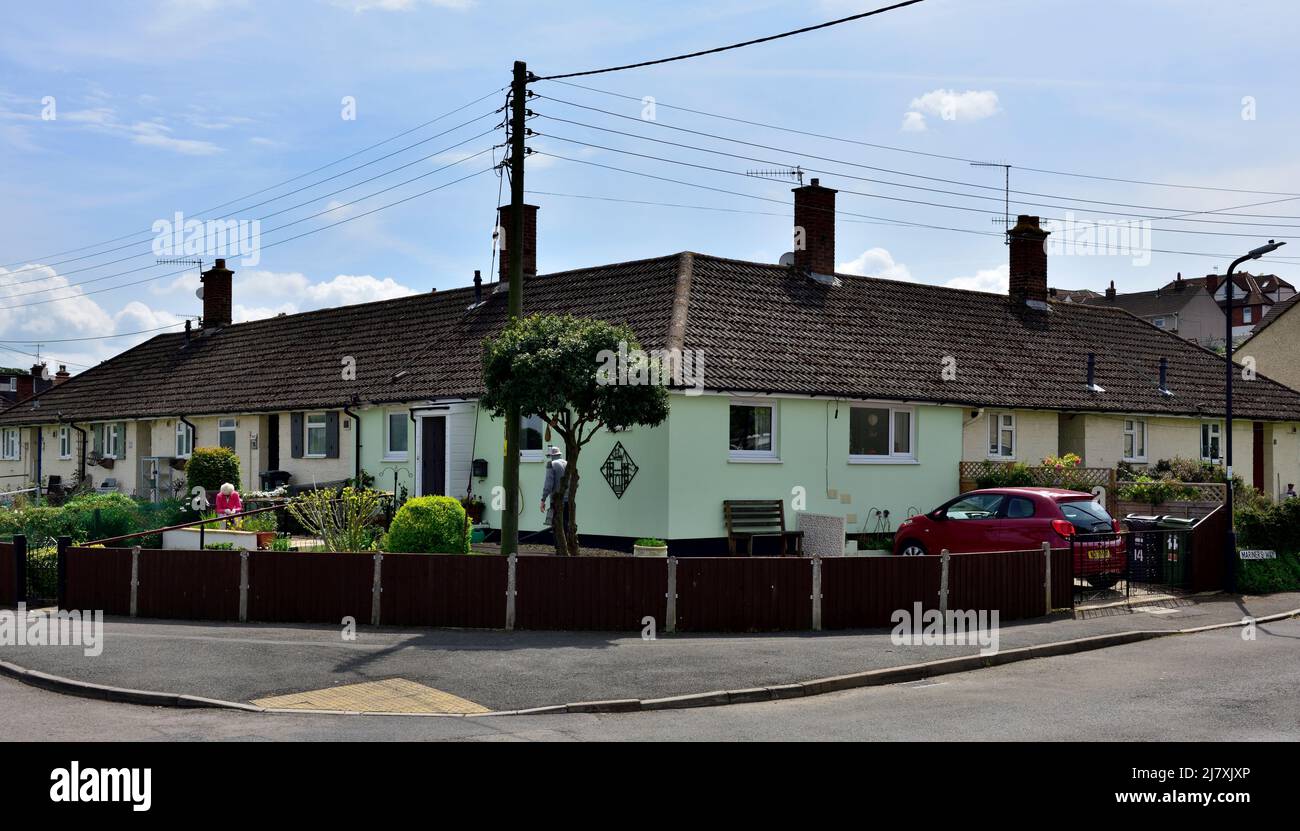 Corner house in row of terraced bungalows with front gardens, village of Pill, North Somerset