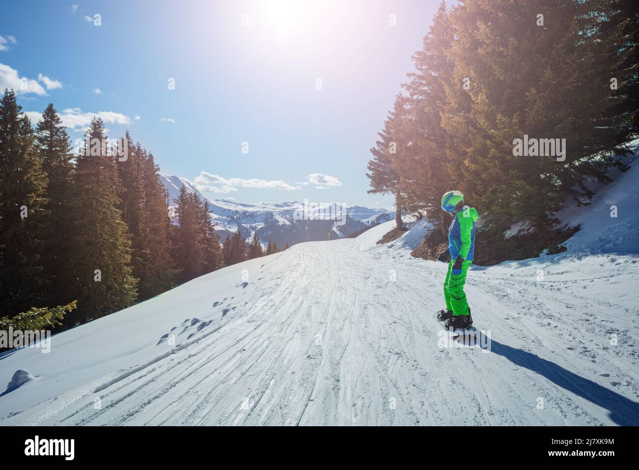 Boy on snowboard go downhill and mountains tops behind Stock Photo - Alamy