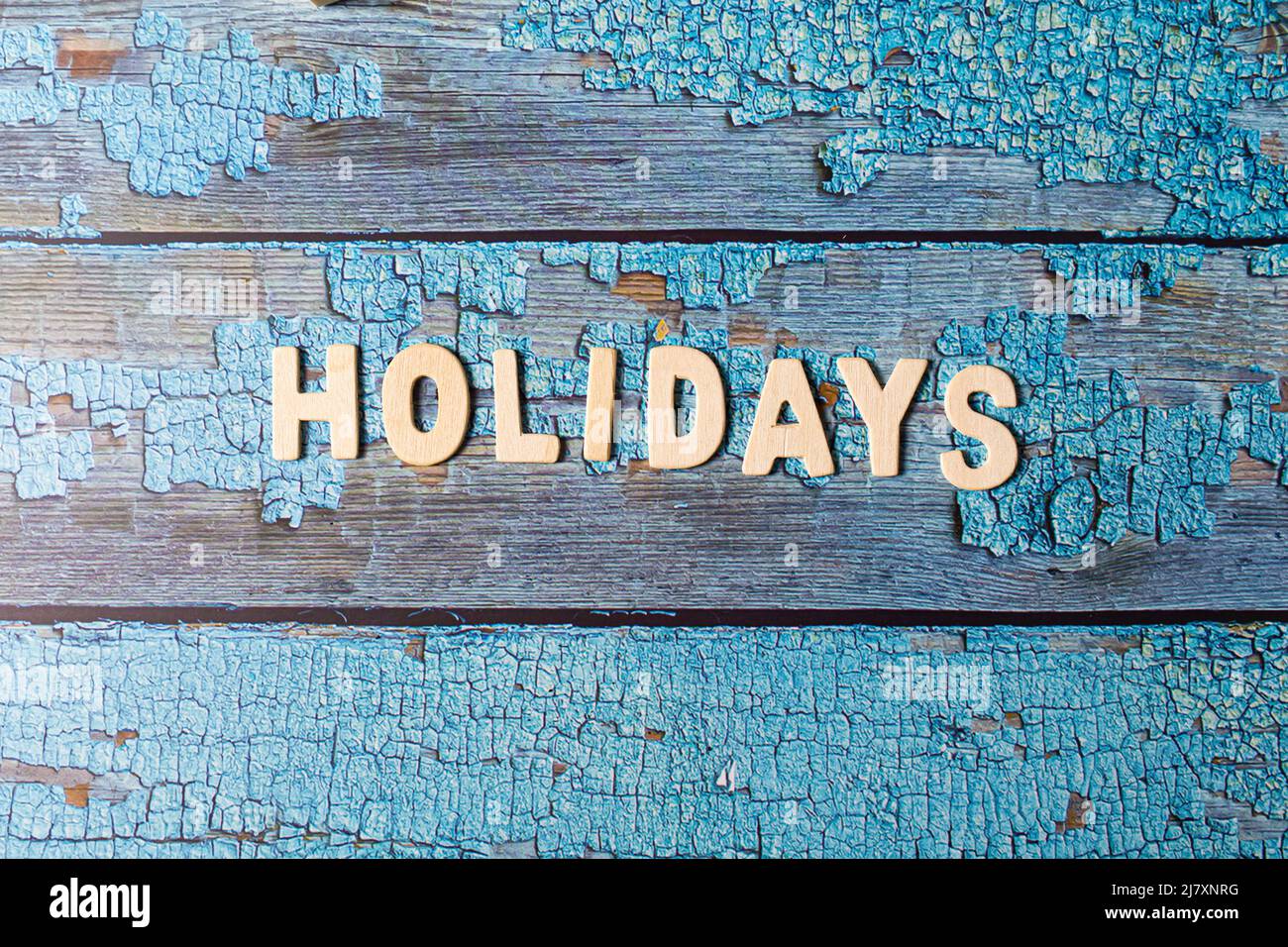 Holidays text word written on wooden letters on a textured blue wooden board Stock Photo